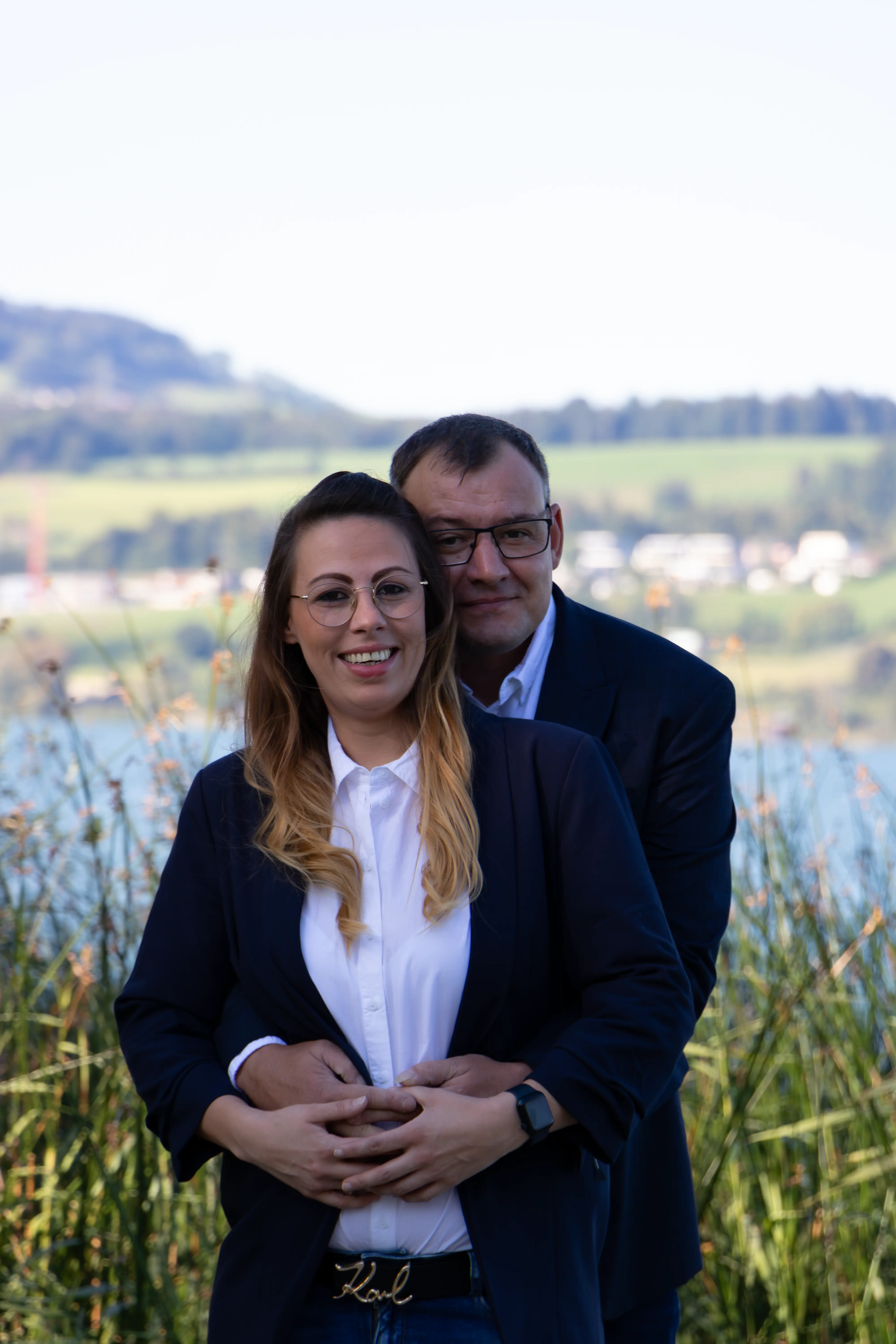 Päärchenfotografie: Junges Päärchen hält sich Arm in Arm beim See-Shooting