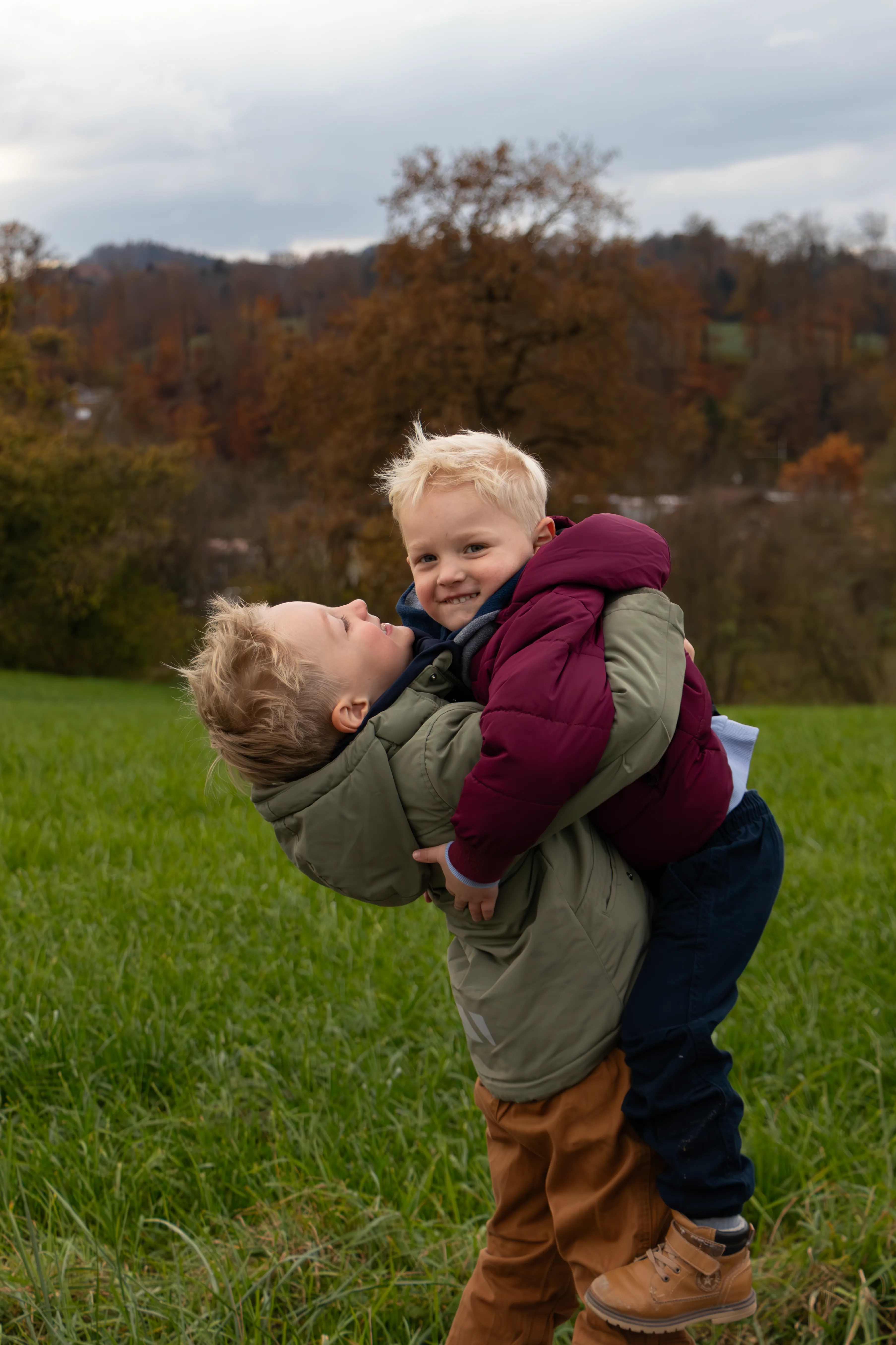Zwei Jungen. Der eine Junge hebt den anderen Jungen in die Luft.